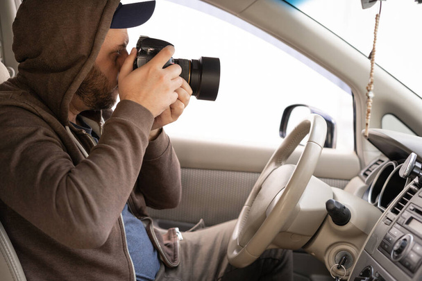 Мужчина-водитель фотографирует с камерой Slr из машины крупным планом - Фото, изображение