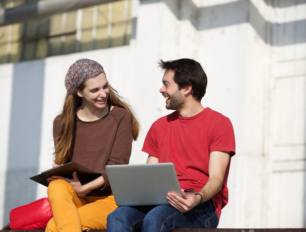 Два студента колледжа разговаривают и работают на открытом воздухе на ноутбуке
 - Фото, изображение