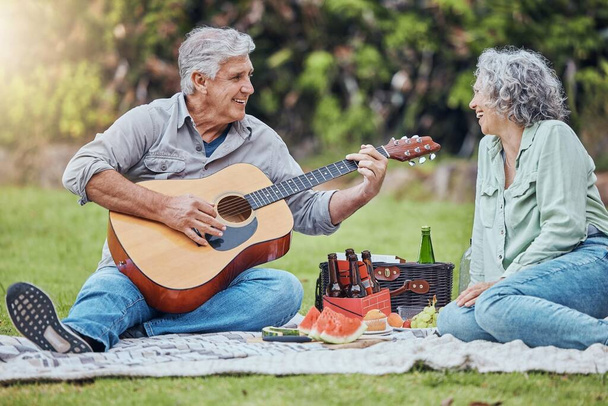 Emerytura, miłość i gitara z parą na pikniku w parku razem na relaks, lato lub jedzenie. Natura, wellness i szczęśliwy starzec i kobieta słuchający muzyki na wsi dla zdrowia wiosną. - Zdjęcie, obraz