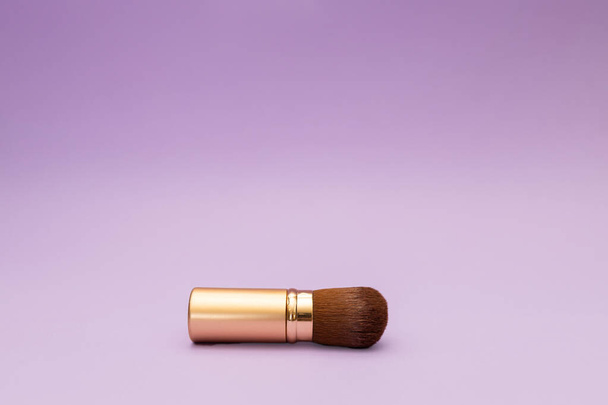Powder brush in gold bottle with magenta background, travel cosmetics - Foto, Imagen