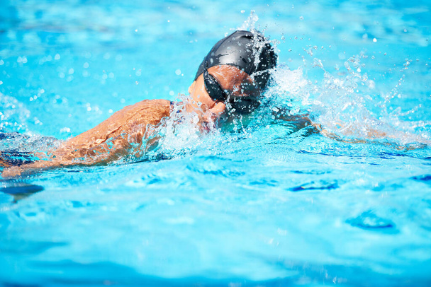 Swimming is all about technique. Female swimmer making her way through a swimming pool stroke by stroke - Fotó, kép