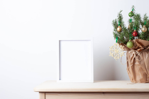 Zero waste Christmas natural decoration with rosemary as alternative Christmas tree and white mock up frame on table. Close up, copy space - Foto, Imagen