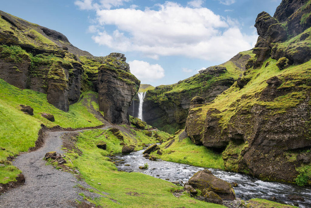 夏のアイスランドの晴れた日に緑の谷を流れるクヴェルヌフォスの滝の壮大な風景 - 写真・画像