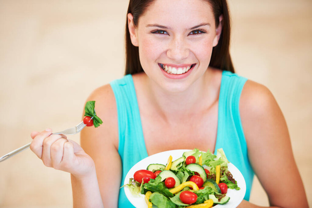 She loves her greens. Portrait of an attractive young woman enjoying a salad - Fotoğraf, Görsel