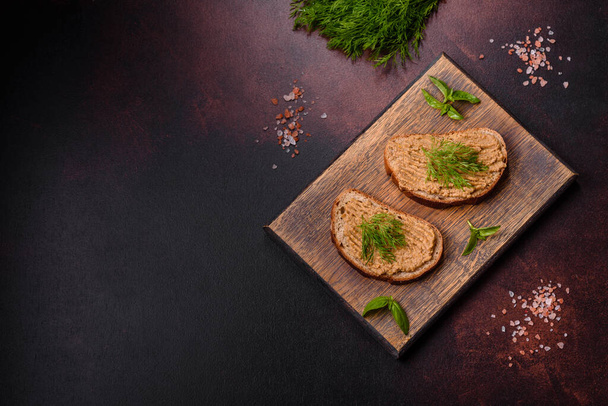Kuřecí játra paštika s chlebem na dřevěné desce přes betonové pozadí - Fotografie, Obrázek