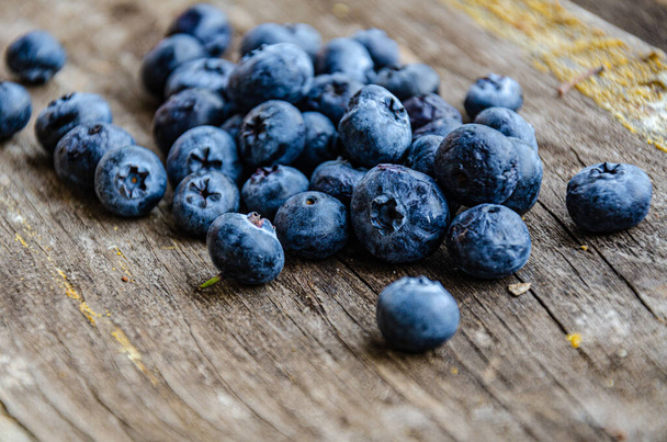 Autumn harvest of blueberries in the garden, lie on an old board. - Foto, Imagem