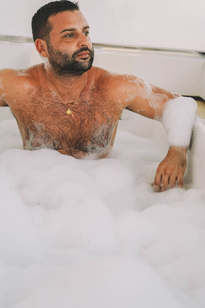 Middle-aged Latin man enjoying a bath with foam and bubbles - Foto, Imagen