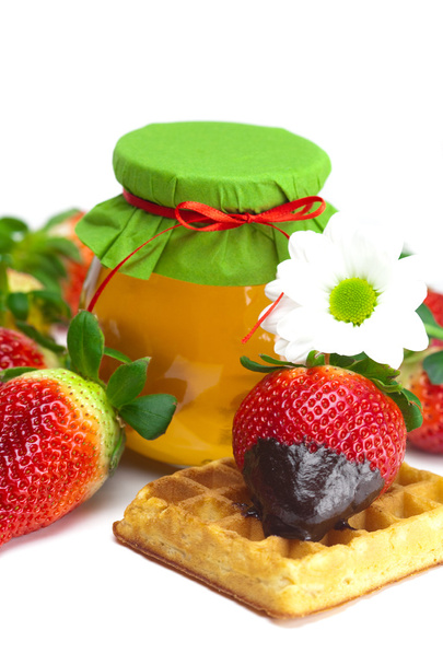Big juicy ripe strawberries in chocolate, a jar of honey and waf - Fotó, kép