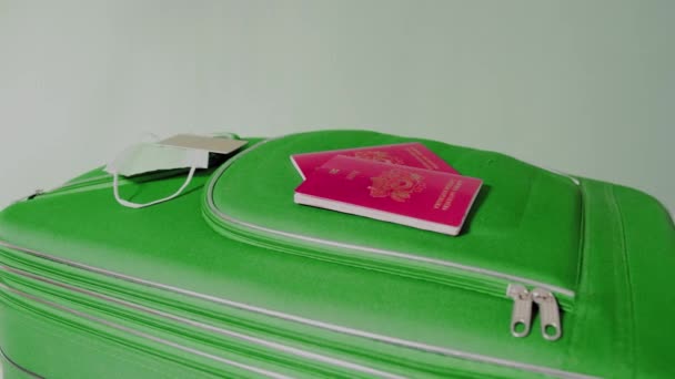 ヨーロッパのパスポート青い壁に対する緑のスーツケースに横になります。高品質4k映像 - 映像、動画