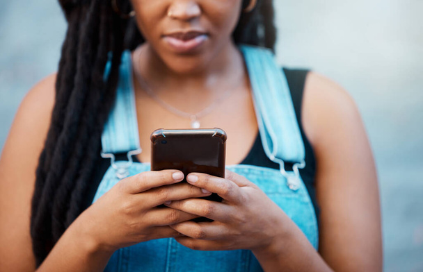 Black woman hands with smartphone for social media, website contact information or reading online blog newsletter in youth urban lifestyle. Teenager with cellphone typing on chat app or 5g networking. - Photo, image