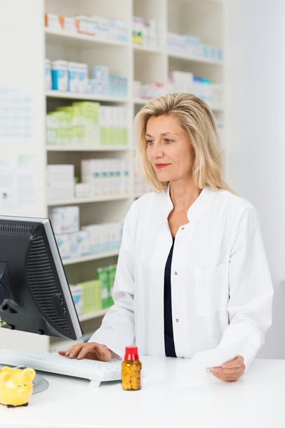 Pharmacist checking stock on computer - Foto, Bild