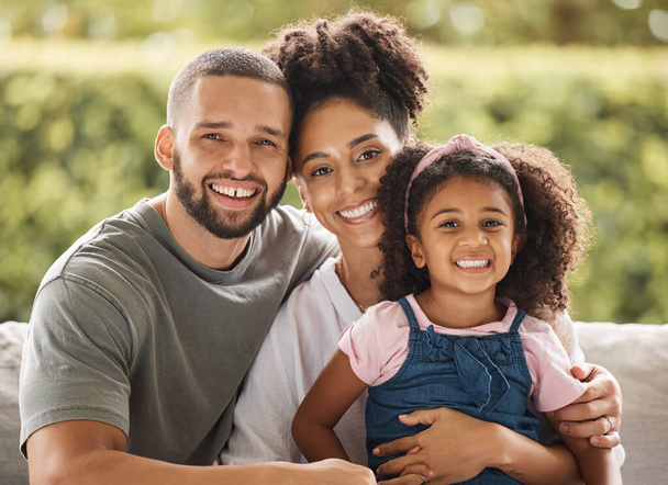 Happy family, mother and father with their child love being home for bonding, quality time and relaxing together. Smile, mom and dad enjoy hugging and connecting with their young girl on the weekend. - Photo, Image