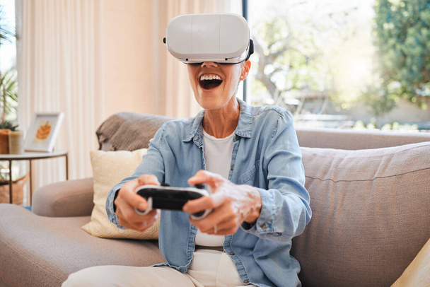 VR, metaverse and 3d gaming with a woman playing a video game on a sofa in the living room of her home. Virtual reality, esports and technology with a female gamer enjoying an online experience. - Foto, Bild
