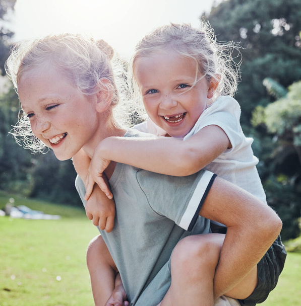 Onnellinen, hymy ja sisarukset ulkona puistossa kesällä hauskaa ja leikkii luonnossa. Onnellisuus, innoissaan ja tyttö lapset seikkailu antaa possu takaisin ratsastaa ulkona vihreässä puutarhassa - Valokuva, kuva