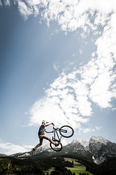 Joven truco truco de motociclista salta truco alto sobre las montañas de Alp
 - Foto, Imagen