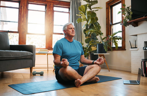 Senior man, yoga meditation and home workout in lotus pose for fitness, peace and zen energy. Calm mindset, focus wellness and healthy retirement on living room floor for balance, breathing and relax. - Fotografie, Obrázek
