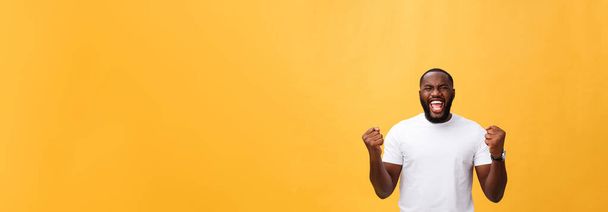 Pohledný mladík Afro-American zaměstnanec pocit vzrušení, ukázal aktivně, držet pěsti zaťaté, radostně volat s ústa otevřela, spokojený s štěstí nebo povýšení v práci. - Fotografie, Obrázek