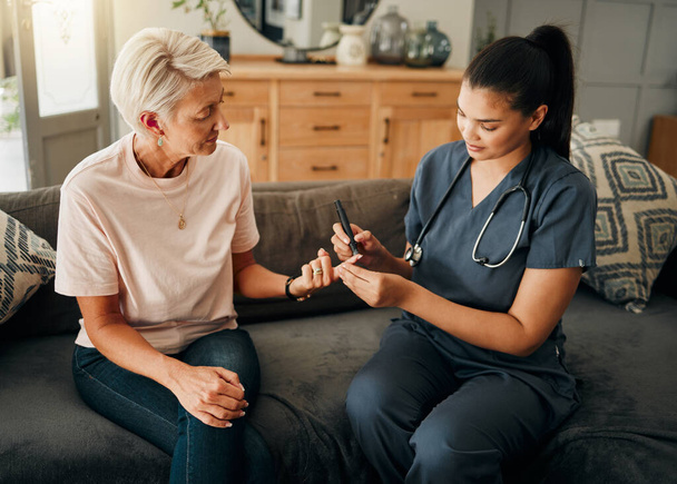Diabetes, healthcare nurse and elderly woman finger doing blood test, sugar or medical test with a glucometer. Insurance doctor, health or diabetic senior lady consulting her glucose wellness at home. - Fotoğraf, Görsel