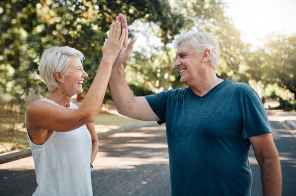 High five, success or senior couple fitness in running workout, exercise or training in nature park or Canada garden. Smile, happy or sports teamwork gesture for retirement man and woman health goals. - Photo, image