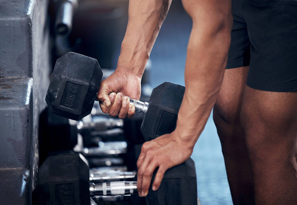 Closeup of man, workout and hands weightlifting with dumbbell in gym for health, fitness and muscle development. Strong, bodybuilder and exercise for sports, wellness and motivation in training club. - Photo, Image