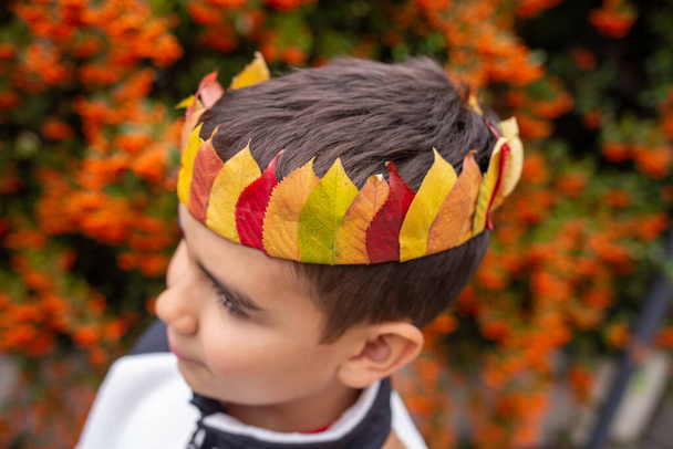 мальчик с осенней короной леса, осенние листья ремесла, изучение природы для детей концепции, избирательный фокус - Фото, изображение
