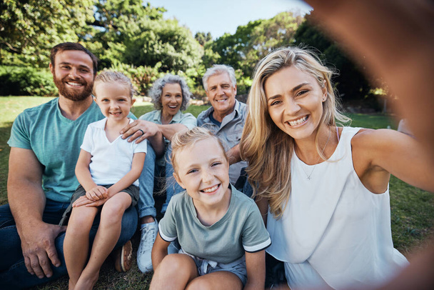 Family selfie, park portrait and woman with smile on holiday in nature in Canada during summer. Parents, girl kids and grandparents taking photo on vacation in a green garden for picnic in spring. - Foto, afbeelding