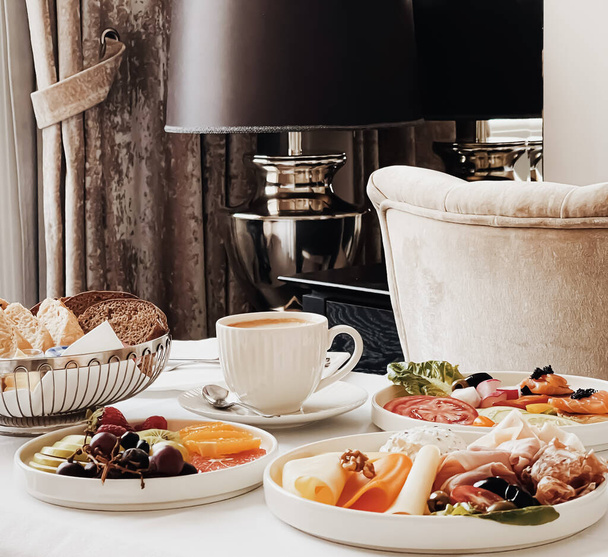 Luxury hotel and five star room service, various food platters, bread and coffee as in-room breakfast for travel and hospitality brand - Фото, зображення
