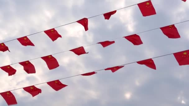 Китайський п'ятизірковий червоний прапор дрібні кольорові прапори пурхають на вітрі - Кадри, відео