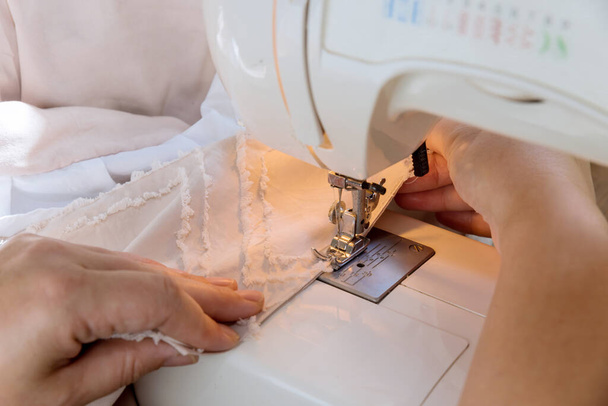 During workday, tailor seamstresses sew clothes on sewing machines in their workplace - Photo, image