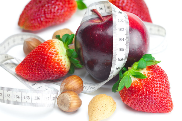 Big juicy red ripe strawberries,apple,nuts and measure tape isol - Фото, изображение