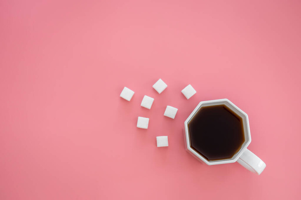 Κύπελλο του καφέ και της ζάχαρης σε κύβους σε ροζ φόντο, επίπεδη lay, αντίγραφο χώρο. - Φωτογραφία, εικόνα