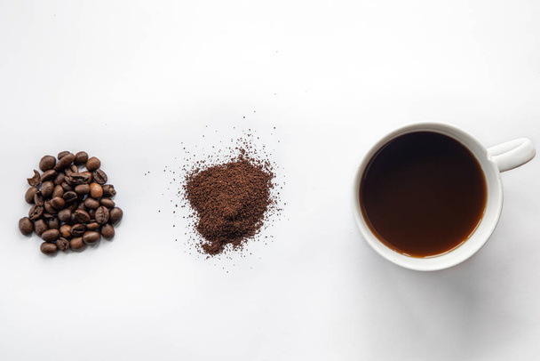 コーヒー豆とコーヒー豆のカップ、白を基調とした平置き、コーヒー作りのコンセプト. - 写真・画像