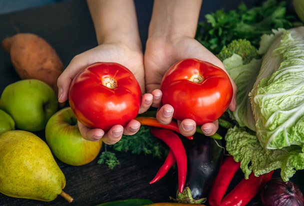 Close-up, tomates em mãos femininas na cozinha, o conceito de cozinhar. - Foto, Imagem