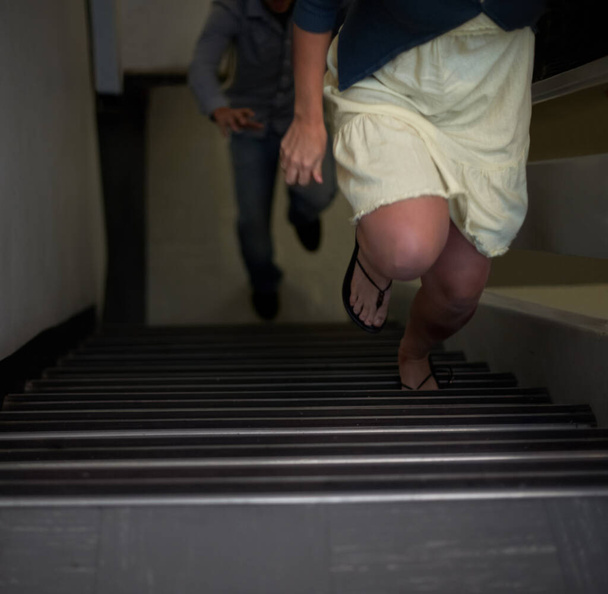 逃げようとしてる。階段の攻撃者から逃れようとしている女性の作物のビュー - 写真・画像