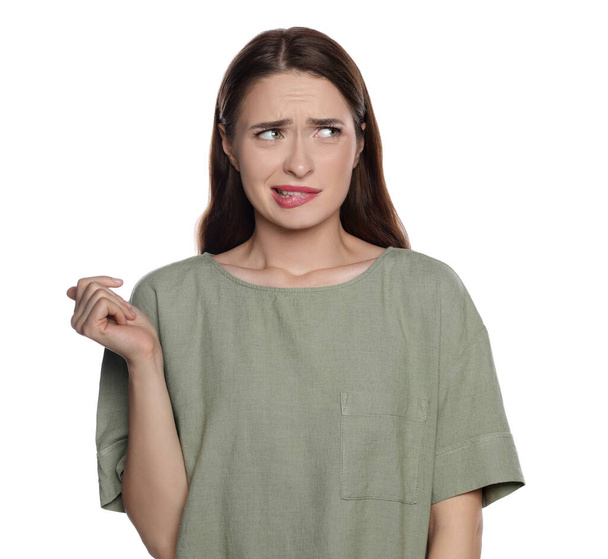 Embarrassed young woman in shirt on white background - Foto, Imagen