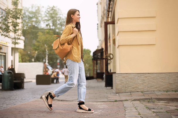 Mladá žena s batohem chůze na ulici města - Fotografie, Obrázek
