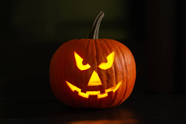 Scary jack o'lantern pumpkin in darkness. Halloween decor - Zdjęcie, obraz