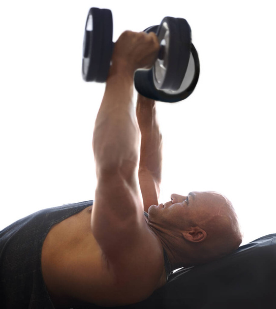 Enfocado en reafirmar. un culturista masculino levantando pesas en el gimnasio - Foto, imagen