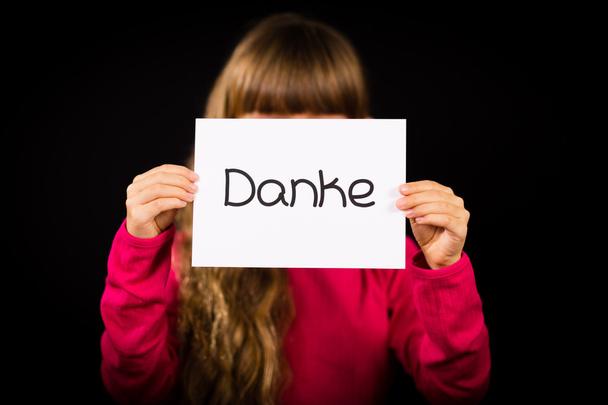 Child holding sign with German word Danke - Thank You - Foto, imagen