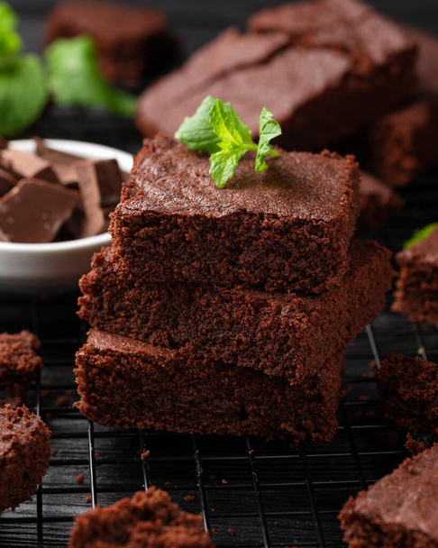 Chocolate brownies garnished with mint on cooling rack. Sweet food. - Photo, Image