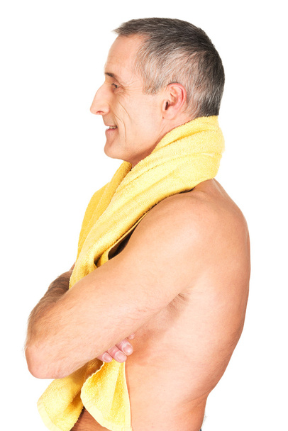 Side view mature man holding towel around neck - Foto, afbeelding