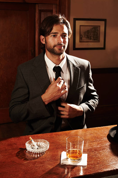 Csak nyugalom. Egy jól öltözött fiatalember portréja, aki egy bárban ül egy itallal. - Fotó, kép