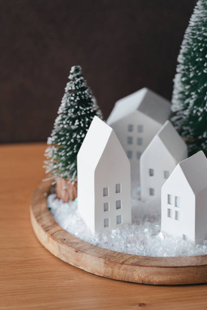 Natale graziose casette con albero di neve su vassoio di legno. Luce splendente. Atmosfera accogliente con decorazione domestica con attenzione selettiva. Biglietto di Capodanno - Foto, immagini