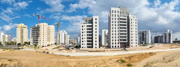 Stadtbau zwischen Wüstendünen. Bauhof der Wohnungsbau von Häusern in einem neuen Bereich der Stadt Holon in Israel - Foto, Bild
