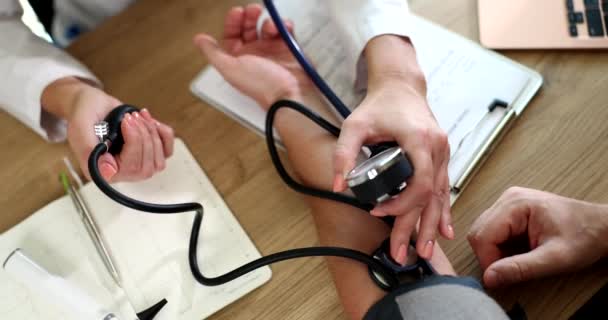 Жіноча медсестра вимірює високий низький кров'яний тиск для пацієнта чоловічої статі з тонометром. Догляд за жінкою-лікарем регулярно перевіряє чоловіка-клієнта в лікарні
 - Кадри, відео