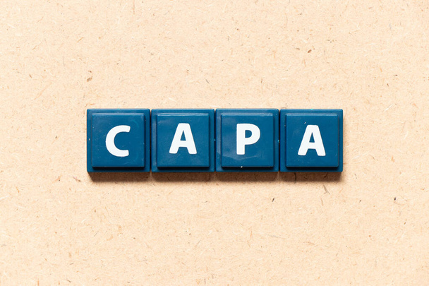 Carta al azulejo en inglés palabra de CAPA (abreviatura de acción correctiva y acción preventiva) sobre fondo de madera - Foto, imagen