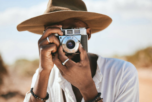 Tourist, photographer and black man with camera to take photograph or pictures during travel adventure in summer on nature vacation. Closeup of male on photography trip holiday outdoors in safari. - Foto, Imagem