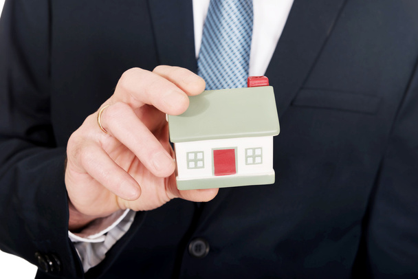 Close up on businessman hand holding house model - Фото, изображение