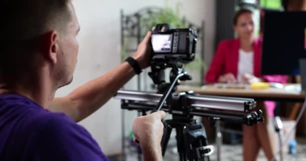 Αρσενικό videographer κινηματογραφεί μια επιχειρηματίας στην επιφάνεια εργασίας στο γραφείο. Βίντεο blog για την ανάπτυξη και την κατάρτιση των επιχειρηματιών - Πλάνα, βίντεο