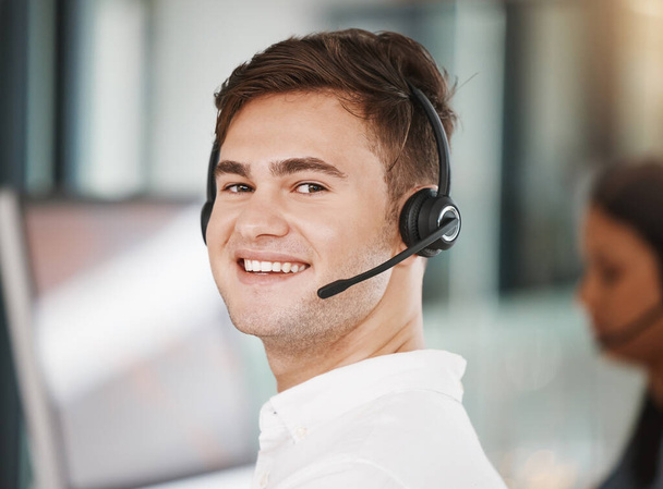 Portrait of a call center consultant working in an office doing a crm strategy with headset. Happy, professional and young telemarketing agent doing ecommerce sales and customer support operation - Photo, Image